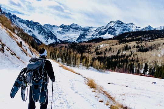 man wearing backpack on snow