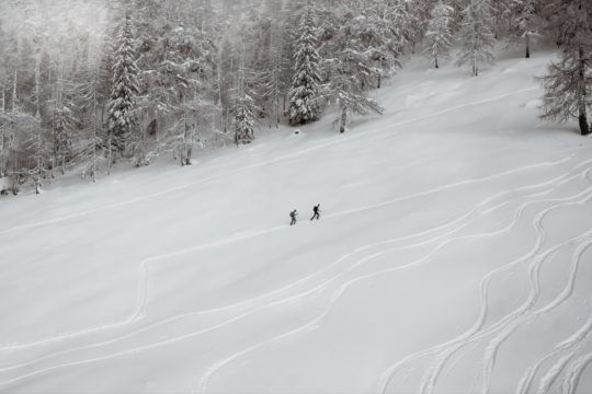 person riding ski board on snow covered ground during daytime