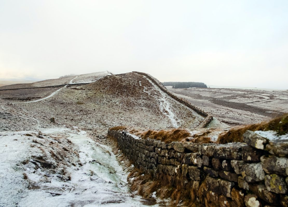landscape photography of grey bricked wall near mountain